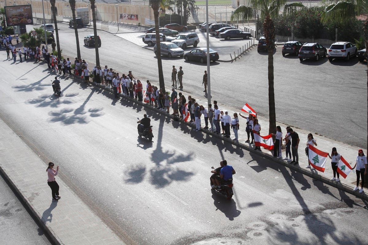 Lebanese protesters hold hands to form a human chain along the coast from north to south as a symbol of unity, during ongoing anti-government demonstrations in the southern Lebanese port city of Sidon on October 27, 2019. (AFP)