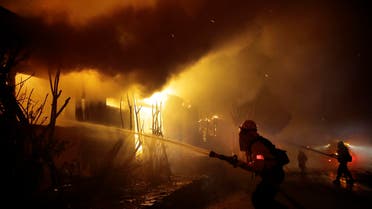 Firefighters try to hose down flames as homes burn in the Getty fire area along Tigertail Road, Monday, Oct. 28, 2019, in Los Angeles. (AP)
