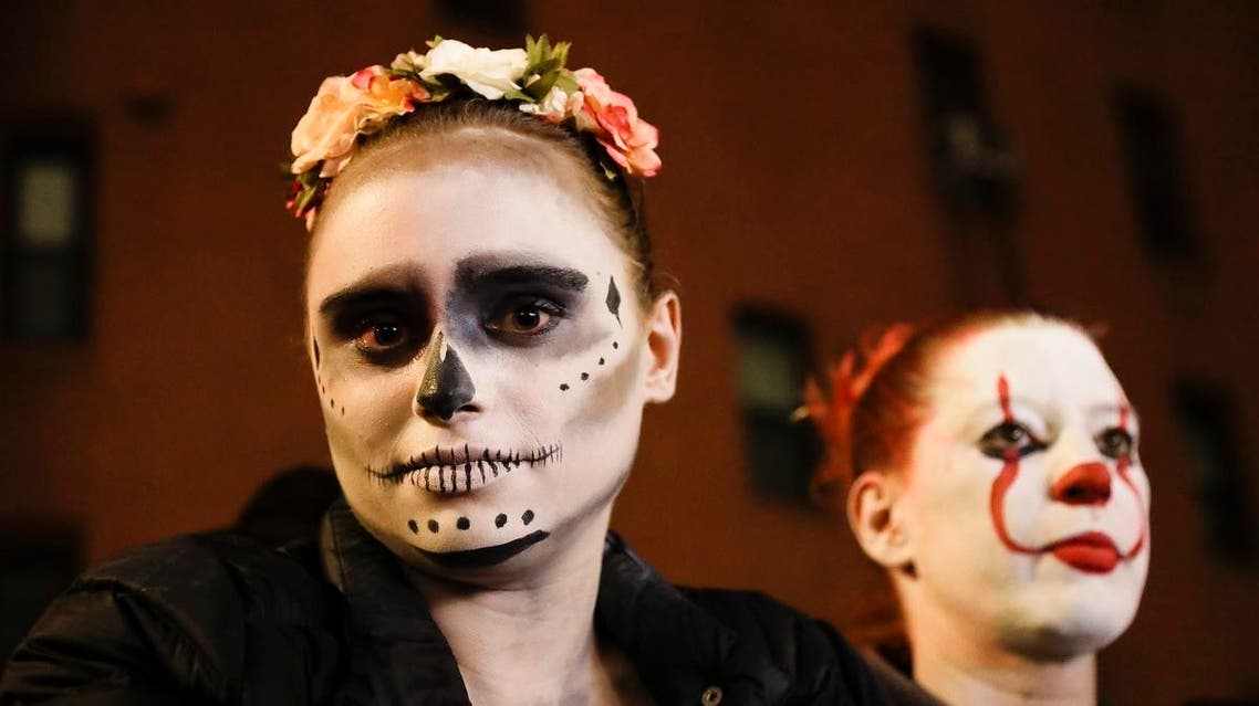 Leni Wild poses with others as they watch revelers march during the Greenwich Village Halloween Parade. (AP)