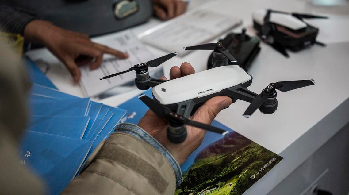 n this file photo taken on May 4, 2018 a visitor looks at a drone from the Chinese company DJI at the Beijing Photo fair. (File phot: AFP)