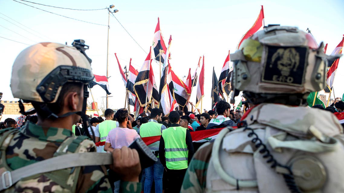 Iraqi security forces stand guard while anti-government protesters gather near Basra provincial council building during ongoing protests in Basra, Iraq, Friday, Nov. 1, 2019. (AP Photo)