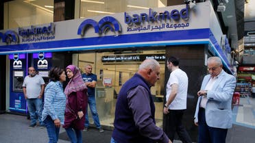 Lebanese clients wait outside a private bank for the opening after two weeks of closer, in Beirut, Lebanon, Friday, Nov. 1, 2019. Lebanon's private banks have reopened after a two-week closure because of anti-government protests. (AP)