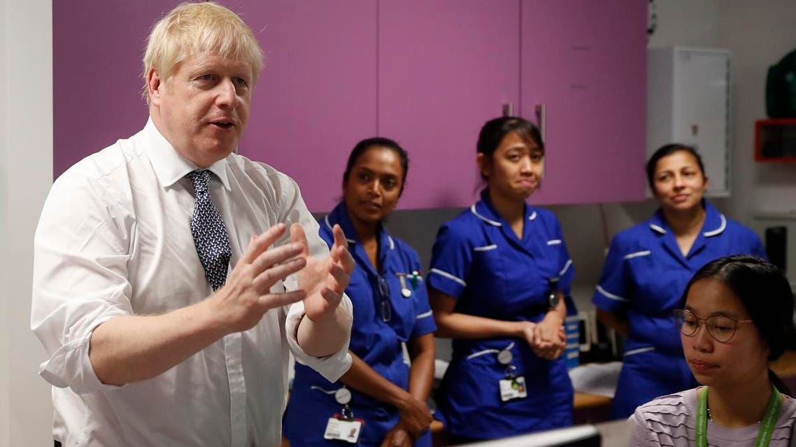Boris Johnson greets and speaks to nurses at National Institute for Health Research at the Cambridge Clinical Research Facility, in Cambridge, England, on October 31, 2019. (AP)