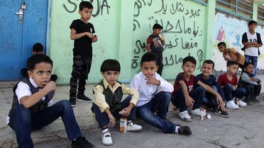 Palestinian refugee pupils wait outside a United Nations Relief and Works Agency’s (UNRWA, UN agency for Palestinian refugees) school, in the Baqa'a Palestinian refugee camp, near Amman, on 2 september 2018. (AFP)