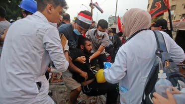 Medics attend to protesters injured in clashes with security forces amidst demonstrations on al-Jumhuriya bridge which connects between the capital Baghdad's Tahrir Square and the high-security Green Zone, hosting government offices and foreign embassies, during the ongoing anti-government protests on October 29, 2019. (AFP)