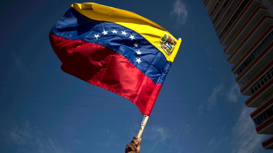 A man waves a representation of Venezuela's national flag during an event in commemoration of the first anniversary of the death of Venezuela's late President Hugo Chavez in Havana, Cuba, Wednesday, March 5, 2014. (AP)