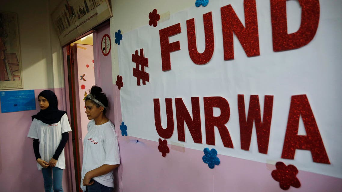 Palestinian refugee students stand outside a classroom as they wait to attend a ceremony to mark the return to school of a new year at one of the UNRWA schools (AP)