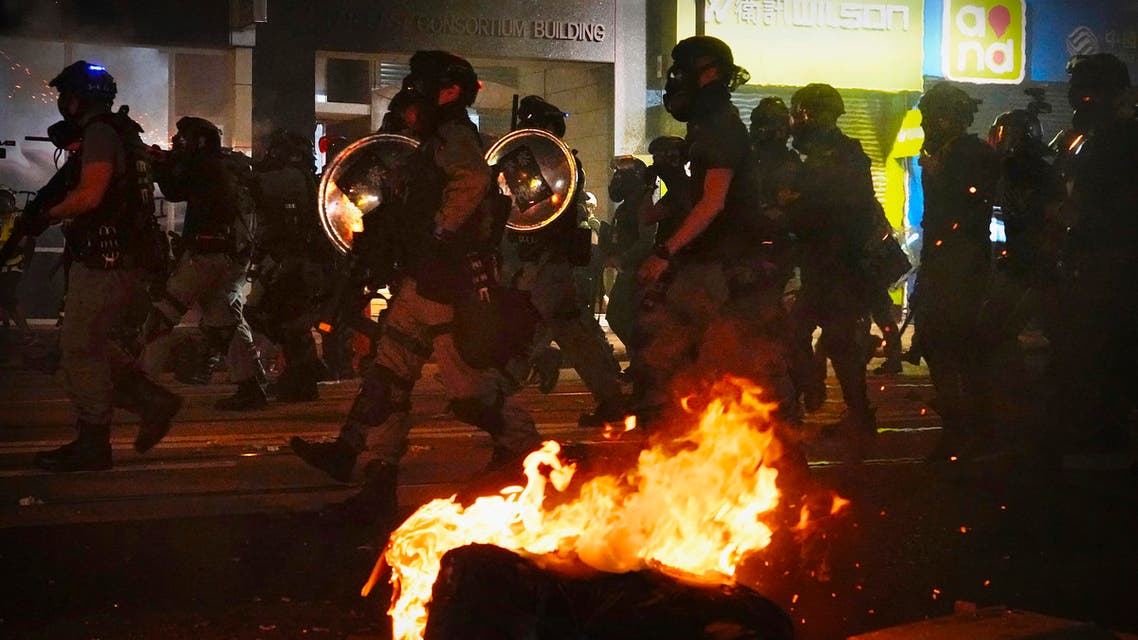 Police in full gear pass burning debris as they walk the streets during a protest in Hong Kong, Saturday, Nov. 2, 2019. (AP)