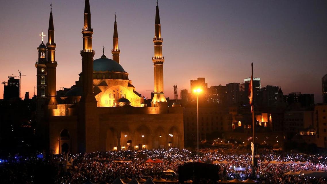 Lebanese anti-government protesters wave national flags as they take part in an anti-government demonstration in front of the Mohammed al-Amin Mosque in the capital Beirut's downtown district on November 3, 2019. (AFP)
