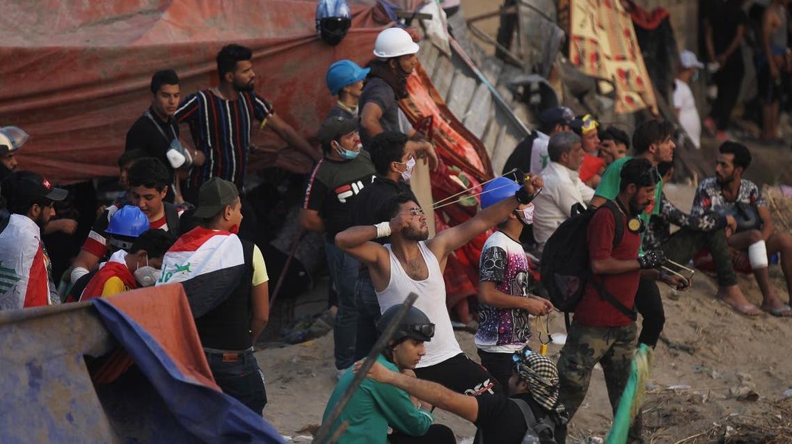 Iraqi demonstrators use sling shots as they gather under the Al-Jumhuriya Bridge in central Baghdad during continuing anti-government protests on November 3, 2019. (AFP)