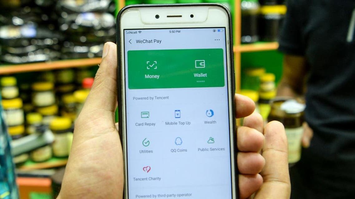 A shopkeeper shows the WeChat app, a Chinese digital wallet on May 21, 2019. (AFP)