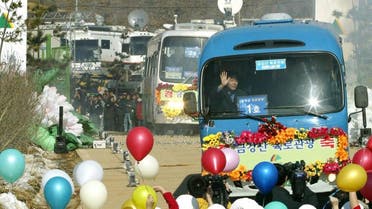 Buses carrying some 400 civilian travellers cross the heavily armed border separating the two Koreas in 2003 for a pilot road trip to the North's Diamond Mountain resort. (AFP)