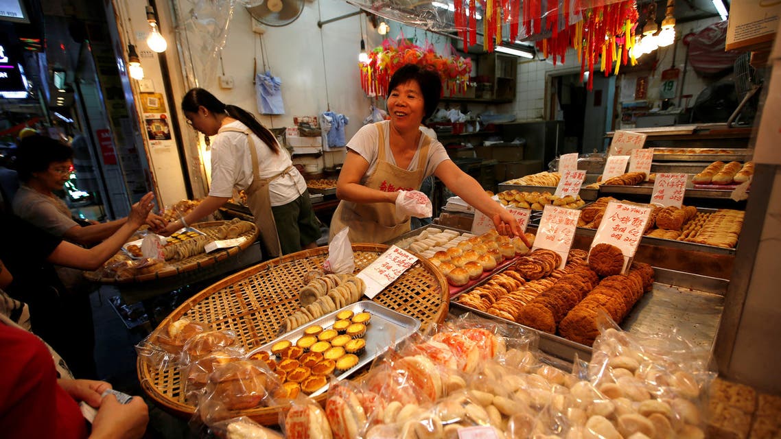 china- reuters Vendors serve their customers at a cake shop at a traditional market in Hong Kong, China