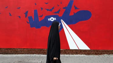 Iran drone mural woman walking past in Iran - AP
