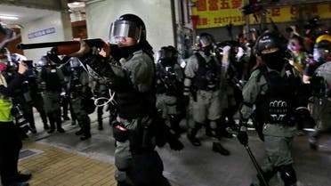 Police officers points his shot gun at protesters during a clash in Hong Kong, early November 9, 2019. (AP)