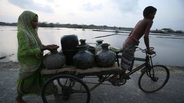 A mother and son transport drinking water on a cart in a cyclone affected area in Shatkhira, 176 kilometers (110 miles) south west of Dhaka, Bangladesh, Wednesday, May 27, 2009. (AP)