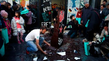 French chocolate maker Patrick Roger, center left, destroys a reproduction of the Berlin wall in chocolate, to mark the 30th anniversary of the fall of the Berlin Wall, in Paris, Saturday, Nov. 9, 2019. (AP)