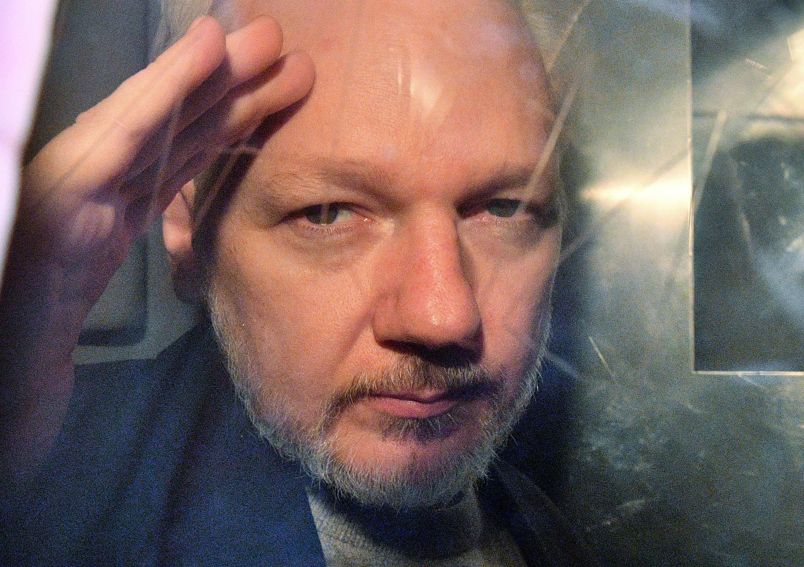 WikiLeaks founder Julian Assange gestures from the window of a prison van as he is driven out of Southwark Crown Court in London on May 1 2019. (Stock image)