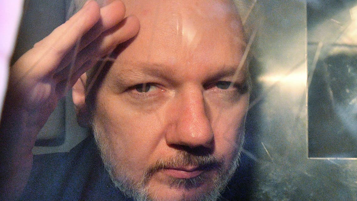 WikiLeaks founder Julian Assange gestures from the window of a prison van as he is driven out of Southwark Crown Court in London on May 1 2019