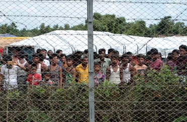 In this June 29, 2018, photo, Rohingya refugees gather near a fence during a government organized media tour, to a no-man's land between Myanmar and Bangladesh, near Taungpyolatyar village, Maung Daw, northern Rakhine State, Myanmar. (AP)