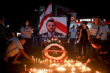 Lebanese demonstrators hold a candle light vigil in the capital Beirut on November 13, 2019, for Alaa Abu Fakhr (photo), killed the day before during ongoing anti-government protests. (AFP)