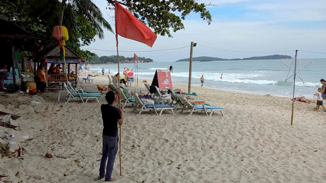 A man raises a red flag indicating rough weather conditions in Chaweng beach, Koh Samui, Thailand, Thursday, Jan. 3, 2019. (AP)