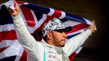 Mercedes AMG Petronas Motorsport driver Lewis Hamilton (44) of Great Britain holds up the Union Jack as he celebrates winning his sixth world championship. (Reuters)