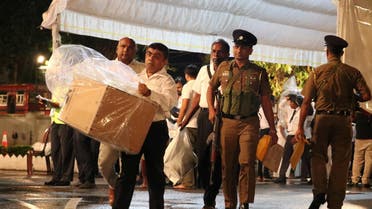Election officials, assisted by Sri Lankan police officer, arrive with a ballot box to a counting center, after the voting ended during the presidential election day, in Colombo. (Reuters)