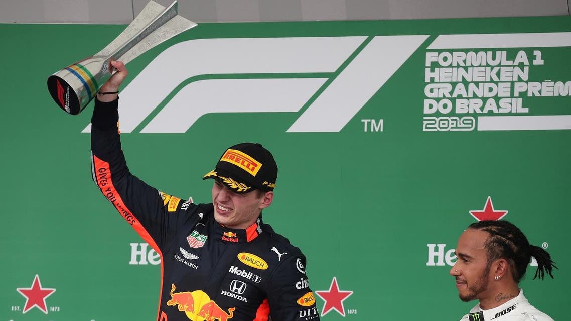 Brazilian Formula One Grand Prix winner Red Bull’s Max Verstappen celebrates on the podium as third placed Mercedes’ Lewis Hamilton looks on. (Reuters)