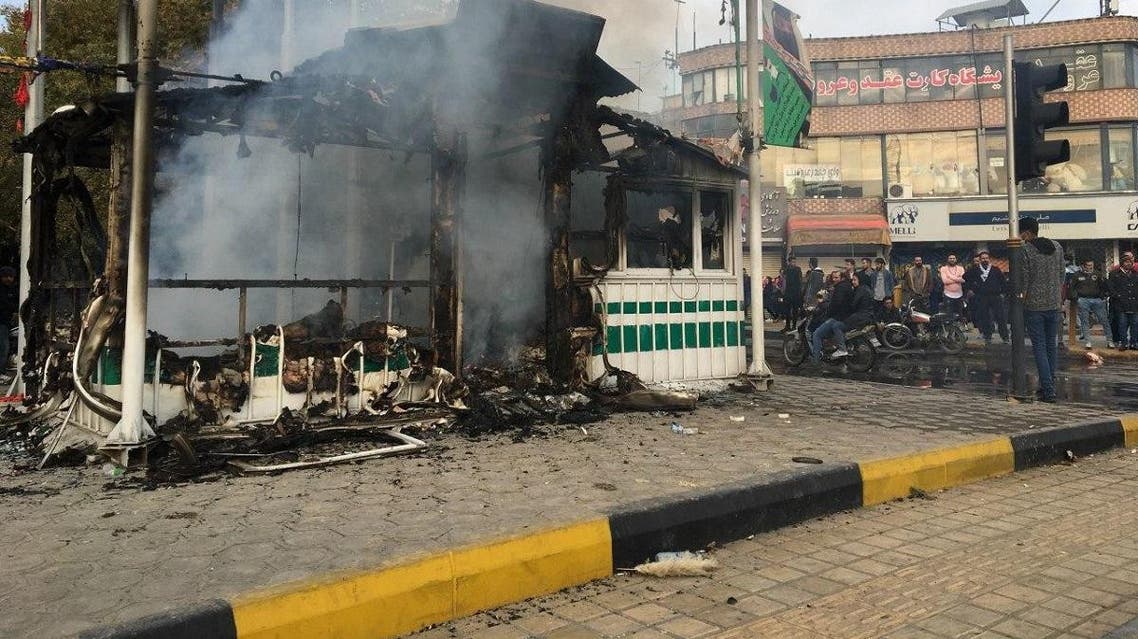 Iranians gather around a charred police station that was set ablaze by protesters during a demonstration against a rise in gasoline prices in the central city of Isfahan on November 17, 2019. (AFP)