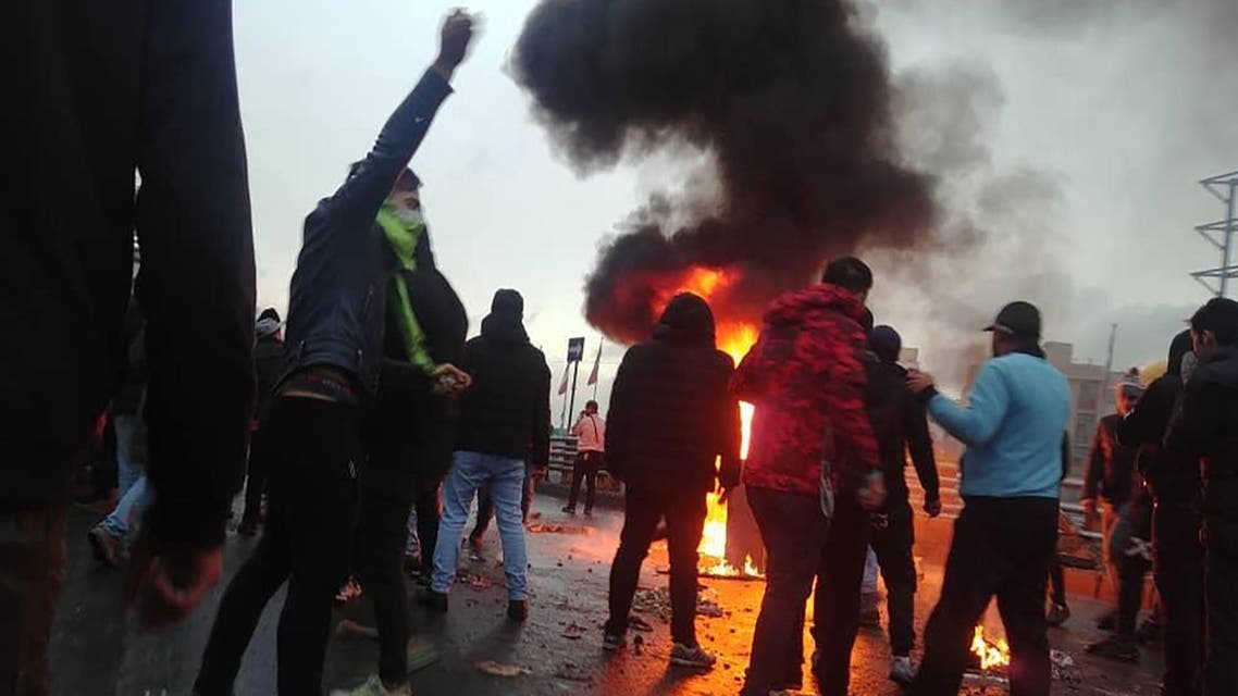 Iranian protesters gather around a fire during a demonstration against an increase in gasoline prices in the capital Tehran, on November 16, 2019. (AFP)