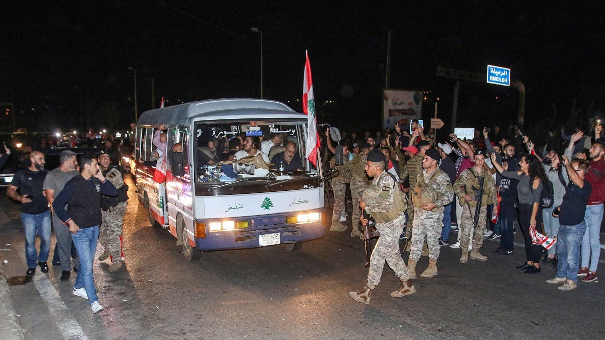 Lebanese anti-government protesters arrive in a “revolution” bus escorted by Lebanese army soldiers in the southern city of Sidon on November 16, 2019. (AFP)