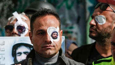 A Palestinian journalist wears a paper eye patch during a demonstration by Israel's controversial separation barrier in Bethlehem in the occupied West Bank on November 17, 2019, in solidarity with Palestinian cameraman Muath Amarneh. (AFP)