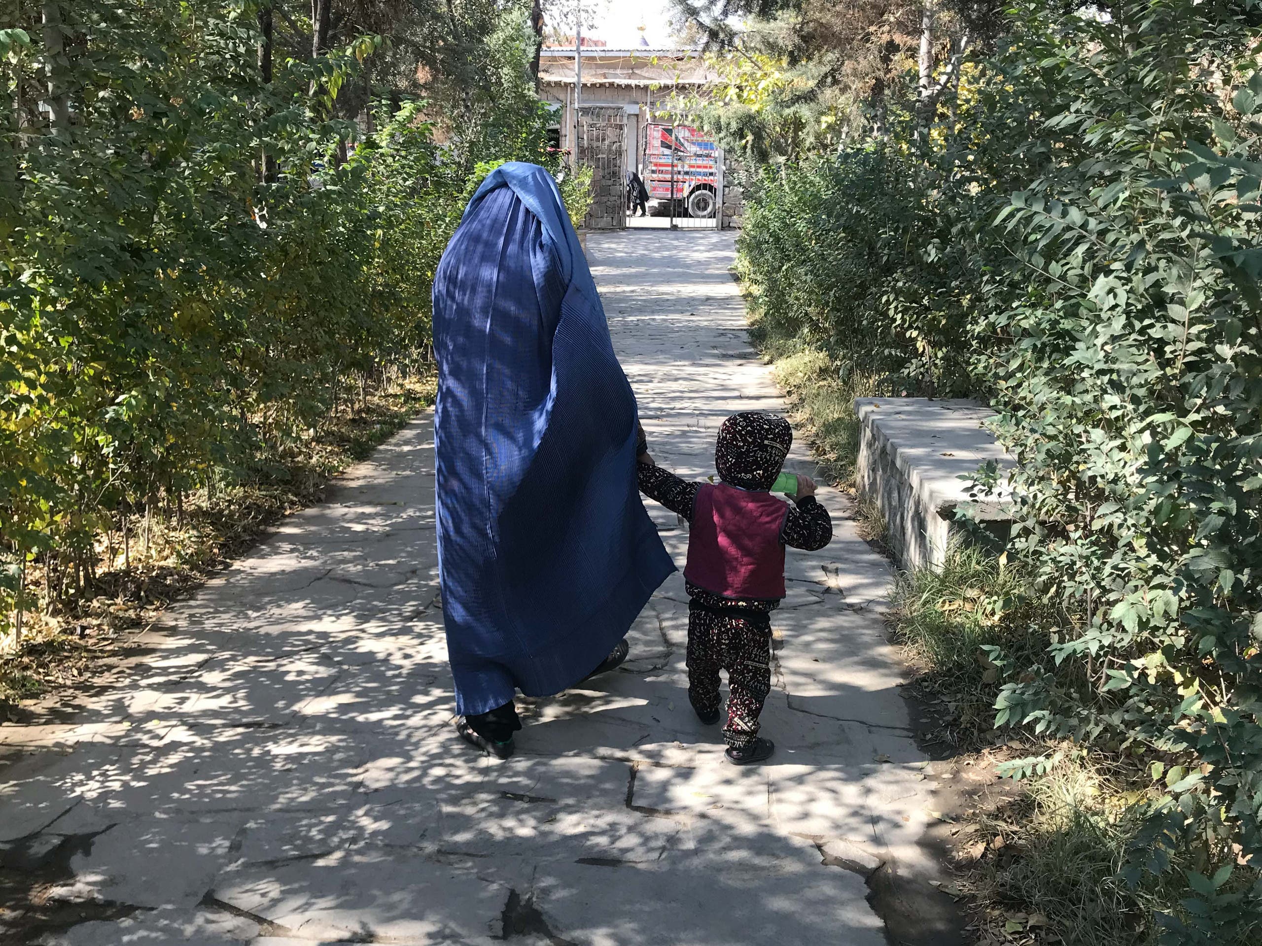 A woman and a child walk in a park that is being upgraded. (Thomson Reuters Foundation/Rina Chandran)