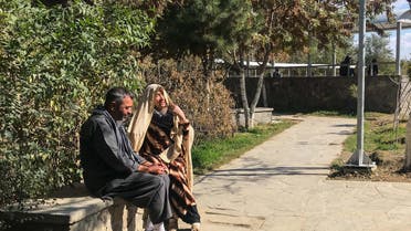 A woman and a man sit on a bench in a park that is being upgraded with wider footpaths, more lights and seating areas as part of a program to make public spaces safer and more accessible for women in Kabul, Afghanistan. (Thomson Reuters Foundation)