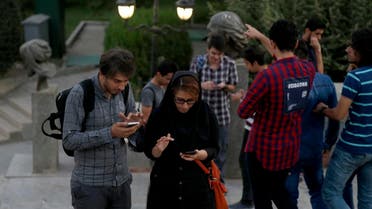 Iranian youths with their smart phones in northern Tehran’s Mellat Park on August 3, 2016. (File photo: AFP)