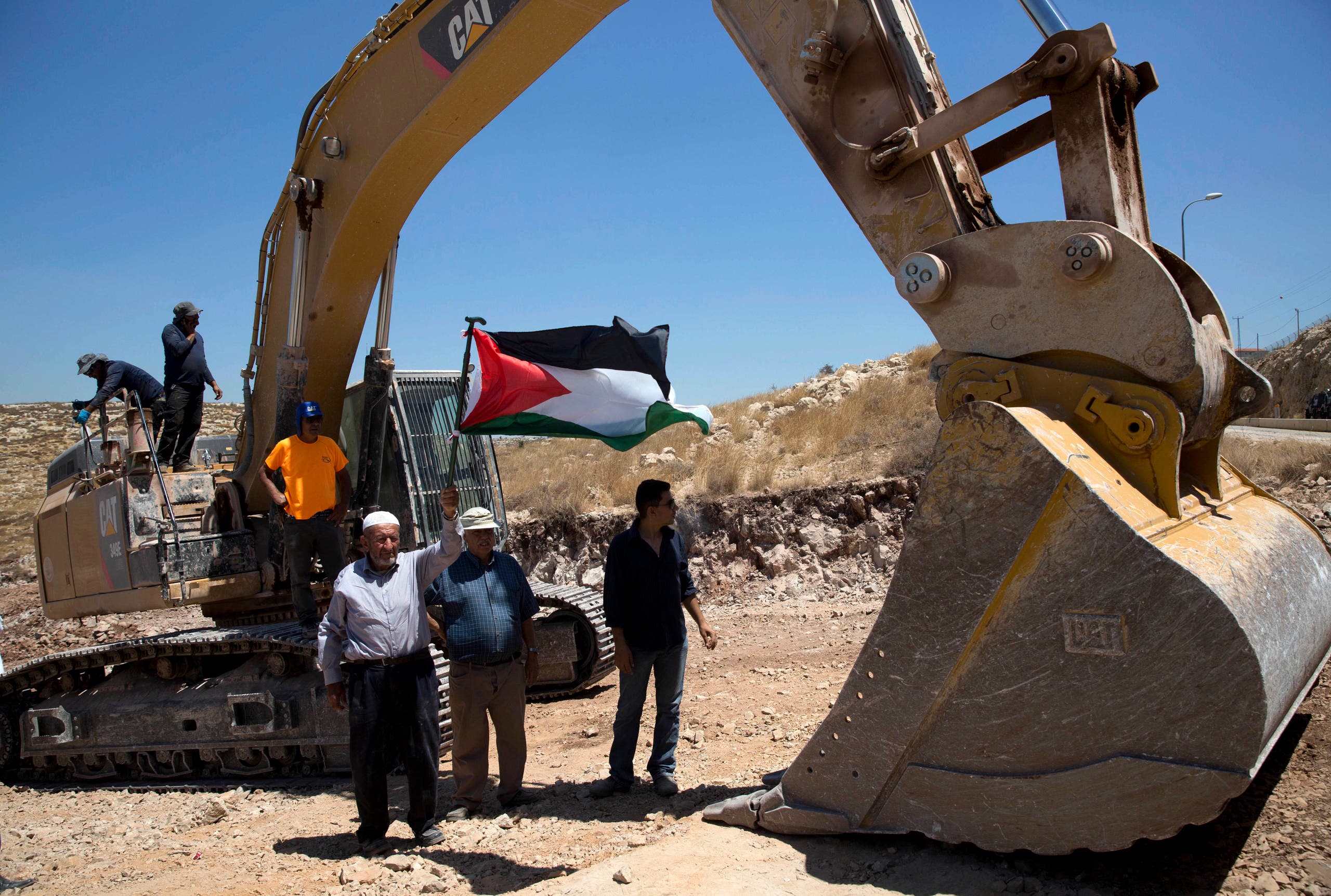 Palestinians demonstrate in front of Israeli bulldozers that were bulldozing land outside Deir Qaddis village near Ramallah for an apparent plan to expand a nearby Jewish settlement. (AP)