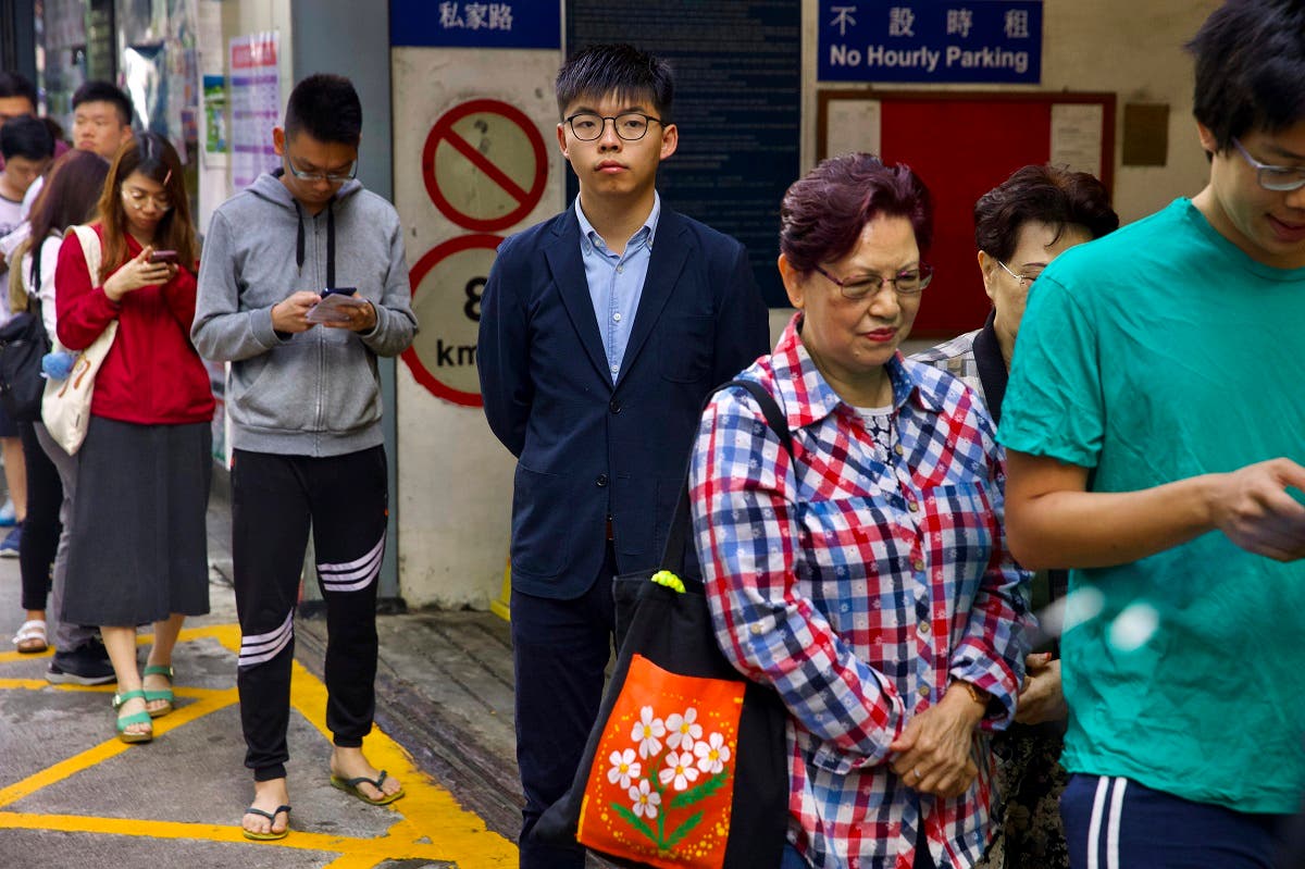 Pro-democracy activist Joshua Wong, center, stands in line to vote outside of a polling place in Hong Kong, Sunday, Nov. 24, 2019. (AP)