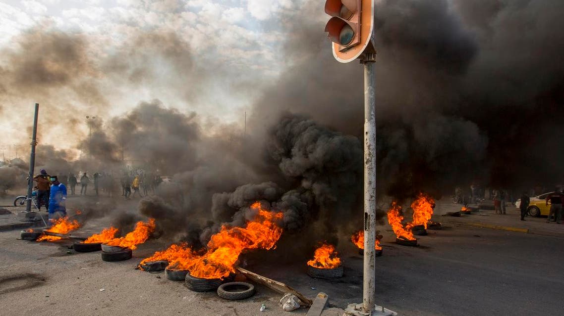 Smoke billows from burning tires during a demonstration in the southern city of Basra on November 24, 2019, as protesters cut-off roads and activists call for a general strike. (AFP)