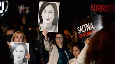 Protesters hold up placards and pictures of the late journalist Daphne Caruana Galizia as they gather outside the prime minister's office in Valletta, Malta on November 20, 2019. (AFP)