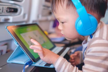 A toddler uses a tablet. (Stock photo)