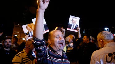Supporters of Lebanese President Michel Aoun chant slogans as they hold his pictures during a protest near the presidential palace in the Beirut suburb of Baabda, Lebanon, Tuesday, Nov. 26, 2019. (AP)