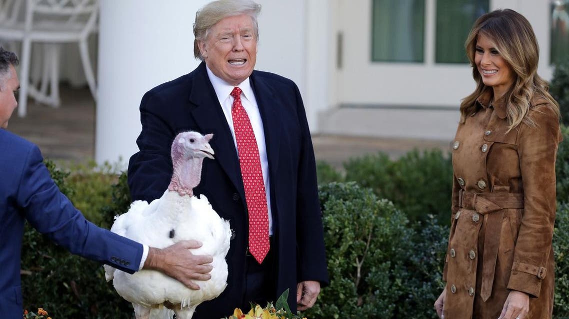  President Donald Trump gives a presidential pardon to the National Thanksgiving Turkey Butter during the traditional event with first lady Melania Trump (R) in the Rose Garden of the White House November 26, 2019. (AFP)