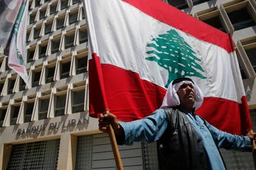 A retired Lebanese soldier holds a national flag, during a protest in front the central bank headquarters, in Beirut, Lebanon, Monday, May 13, 2019. (AP)
