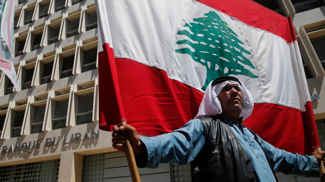 A retired Lebanese soldier holds a national flag, during a protest in front the central bank headquarters, in Beirut, Lebanon, Monday, May 13, 2019. (AP)