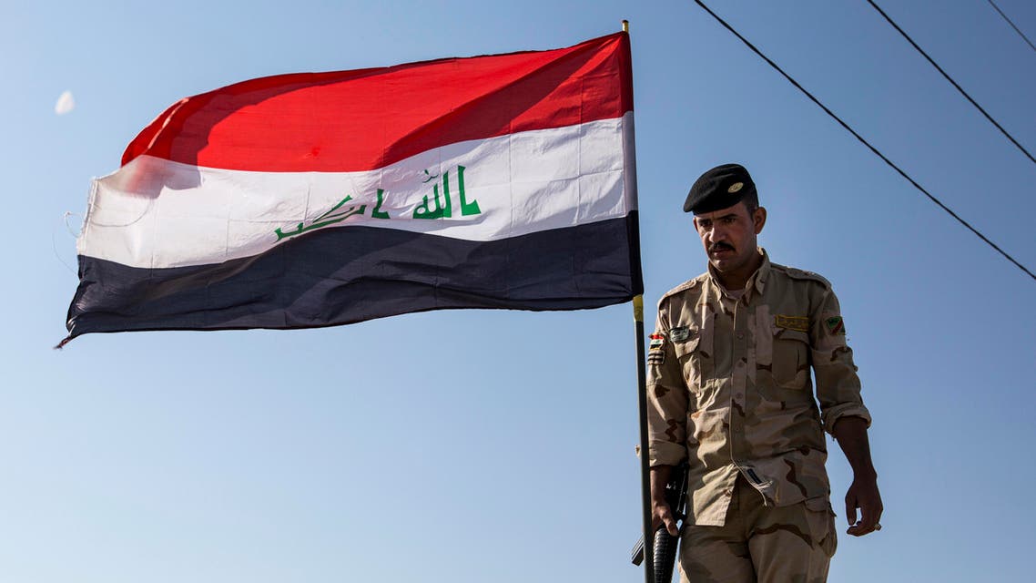 Iraqi soldier holds flag - AFP