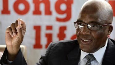 South Africa's Health Minister Aaron Motsoaledi holds the three-in-one combination anti-retroviral (ARV) pill on April 8, 2013 during the launch of the new single dose anti-AIDs drug at Phedisong clinic in Ga-Rankuwa, 100 kms north of Johannesburg. (AFP)