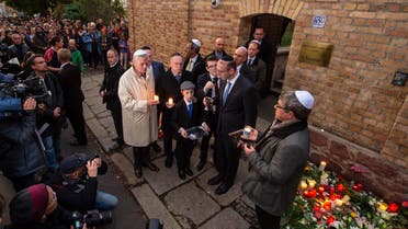 People pray together with Jewish people in front of the synagogue during the Sabbath celebrations in Halle, Germany, Friday, Oct. 11, 2019. (AP)