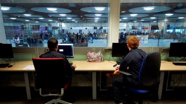 UK Border Force officers work in the watch room overlooking immigration control at Heathrow Airport's Terminal 5. (AP)