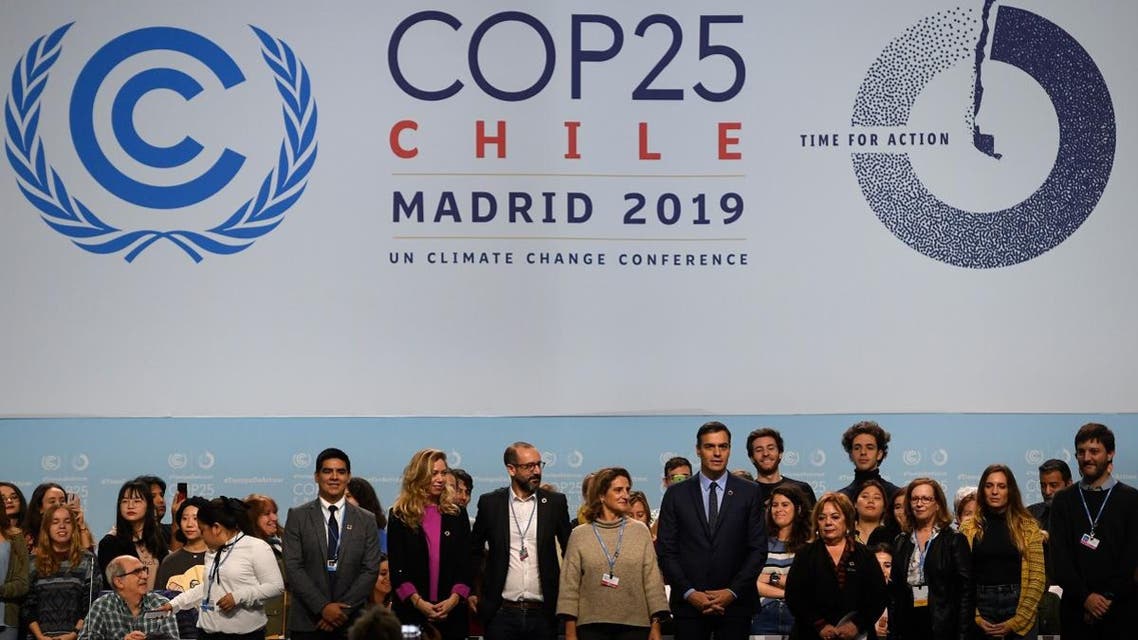 Spain’s PM Pedro Sanchez (C-R) poses with officials and volunteers in Madrid on November 30, 2019 where the COP25 climate summit will be held. (AFP)